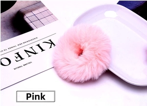 Detailed view of soft pink faux rabbit fur scrunchie on a white minimalist background