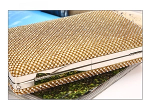 Macro detail of the golden rhinestone evening clutch bag showing stable bottom and craftsmanship