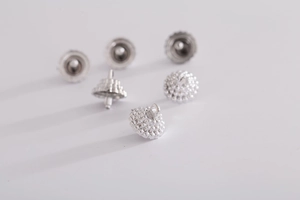 Macro shot of silver metal earring backs and round jewelry components for Christmas ornaments