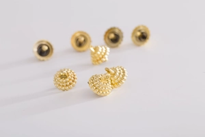 Macro shot of gold textured Christmas ball caps with granular metallic finish details