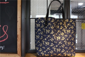 Détail de la toile japonaise bleu marine à fleurs de cerisier d'or et bandoulière cuir