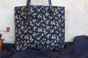 Détail d'un grand cabas en toile marine avec motifs de cerisiers et vagues dorées
