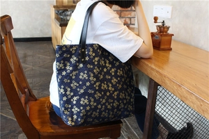 Détail du sac cabas en toile à motifs de cerisiers japonais avec anses en cuir noir