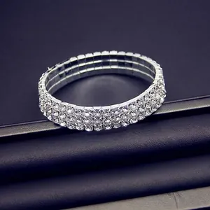 Detailed macro view of silver stretch bracelet with three rows of clear sparkling rhinestones