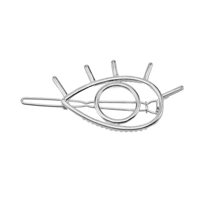 Close-up of geometric silver-toned evil eye hair clip with metal eyelash details
