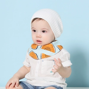Détail d'un ensemble bébé avec bonnet blanc tricoté, bavoir bleu et short en jean
