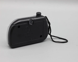 Detail of a black handheld electronic accessory for 18-inch dolls with lanyard and button