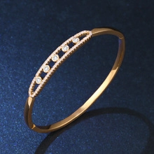 Close-up of rose gold bangle with pave setting diamonds and large clear main stones