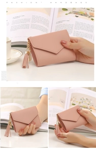 Detail of pink short wallet with tassel fringe and golden heart pendant decoration
