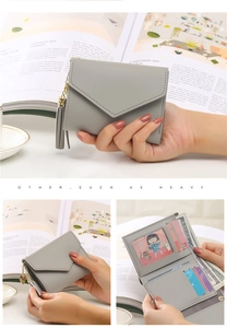 Macro view of grey tri-fold wallet showing card slots, ID window, and tassel detail