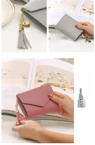 Close-up of pink and grey envelope wallets with heart charms and long tassels