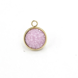 Macro detail of a 12mm round pink resin pendant with gold stainless steel bezel