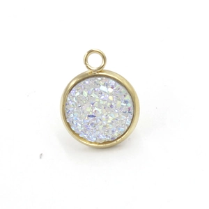 Macro shot of gold round pendant with iridescent white resin crystal inlay DIY accessory