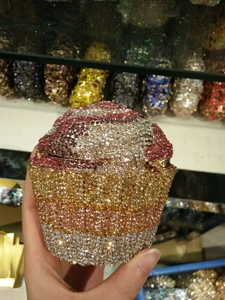 Macro view of crystal encrusted cupcake-shaped clutch evening bag with pink and gold rhinestones