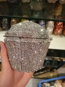Close-up of a silver cupcake-shaped evening clutch bag covered in sparkling crystals