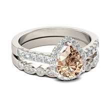 Macro detail of champagne pear cut halo engagement ring set in polished white gold