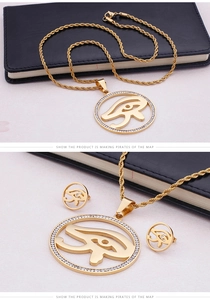 Macro detail of gold plated Eye of Horus necklace and earrings with cubic zirconia