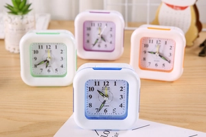 Close-up of square minimalist plastic clocks in blue purple green and orange colors
