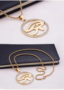 Detail of gold Eye of Horus pendant necklace with clear crystals on rope chain
