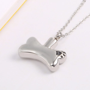 Silver stainless steel dog bone cremation urn necklace with paw prints and heart design