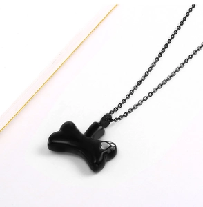 Detailed view of black stainless steel dog bone urn pendant with heart engraving