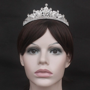 Detail view of a silver bridal crown with leaf patterns on a model's head