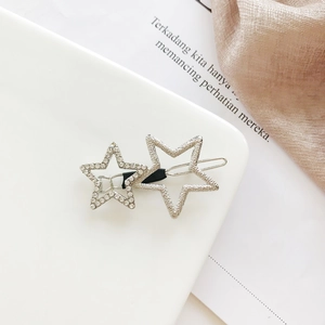 Close-up of silver star hair clip featuring rhinestone inlay and glitter finish