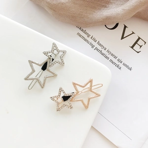 Detailed view of layered star hair clips with crystals in gold and silver plating