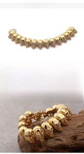 Detailed view of 18K gold plated stainless steel skull bracelet with clear zircon eyes