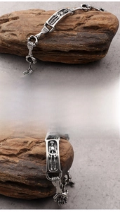 Macro shot of punk skeleton skull links and engraved rectangular plate on steel bracelet