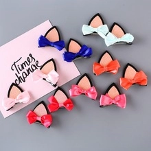Flat lay of colorful sequined cat ear hair clips with satin bows for girls