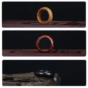 Three-color wooden rings set in natural redwood and ebony with a polished minimalist finish