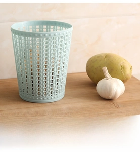 Close-up of light blue plastic hollow storage basket with woven texture on wood tabletop