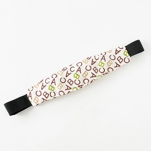 Detail of baby stroller head support belt with ABC pattern and elastic straps