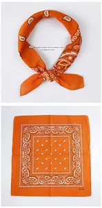 Detailed view of the 100% cotton material and orange paisley pattern on a square scarf