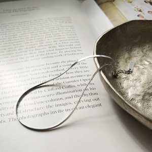 Minimalist S925 sterling silver blade chain anklet styled on an open book and metal bowl