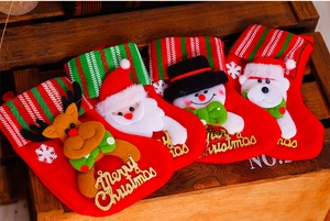 Detail of felt Christmas stockings with cartoon elk and Santa Claus on vintage wood