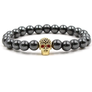 Détail du bracelet en perles d'hématite avec breloque crâne dorée et pierres de zircone noir