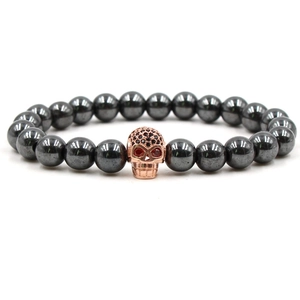 Détails des perles en hématite et du crâne en or rose avec des zircons rouges