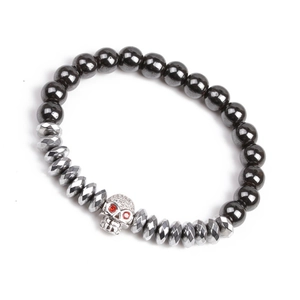 Détail des perles d'hématite et du charm crâne argenté aux yeux en pierres rouges