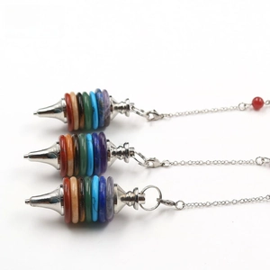 Macro detail of natural 7 chakra crystal pendulum pendants with layered healing stones