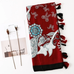 Détail du motif cachemire ethnique et des franges à glands rouges sur un châle en lin