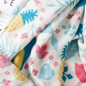 Détail de l'imprimé tropical ananas et fleurs sur châle léger en coton et lin blanc