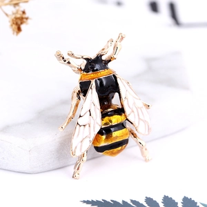 Detailed close-up of a bee brooch with gold plating and colorful enamel finish