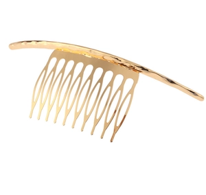 Detail of a 10-tooth gold metal hair comb with a hammered texture curved top bar