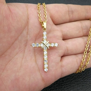 Gold-plated stainless steel cross necklace with AAA zircon stones held by a model
