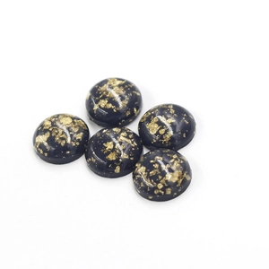 Macro shot of 5 black oval resin stones with sparkling gold foil inlay for jewelry making