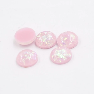 Macro detail of 12mm pink synthetic oval opal resin cabochons with glitter foil effect