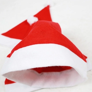 Classic red and white non-woven Christmas hat with white pom-pom on a clean background