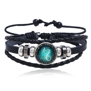 Macro detail of multi-layer Capricorn constellation leather bracelet with woven cords